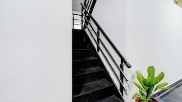 A staircase with black steps and a metal railing.