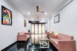 A modern living room with two sofas, a coffee table, and ceiling fans.