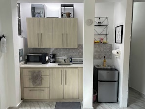 A compact kitchen with a microwave, coffee maker, and a Galanz refrigerator. - Tiny Cozy Studio 15 Minutes Airport, Patio, Small Share Pool one Full bed (San Juan)