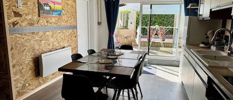 A dining area with a table, chairs, and a view of the outdoors.