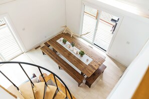 Ein Essbereich mit Holztisch, Bänken und Blumentöpfen.