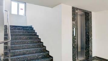 Una escalera con barandilla que lleva a un ascensor.