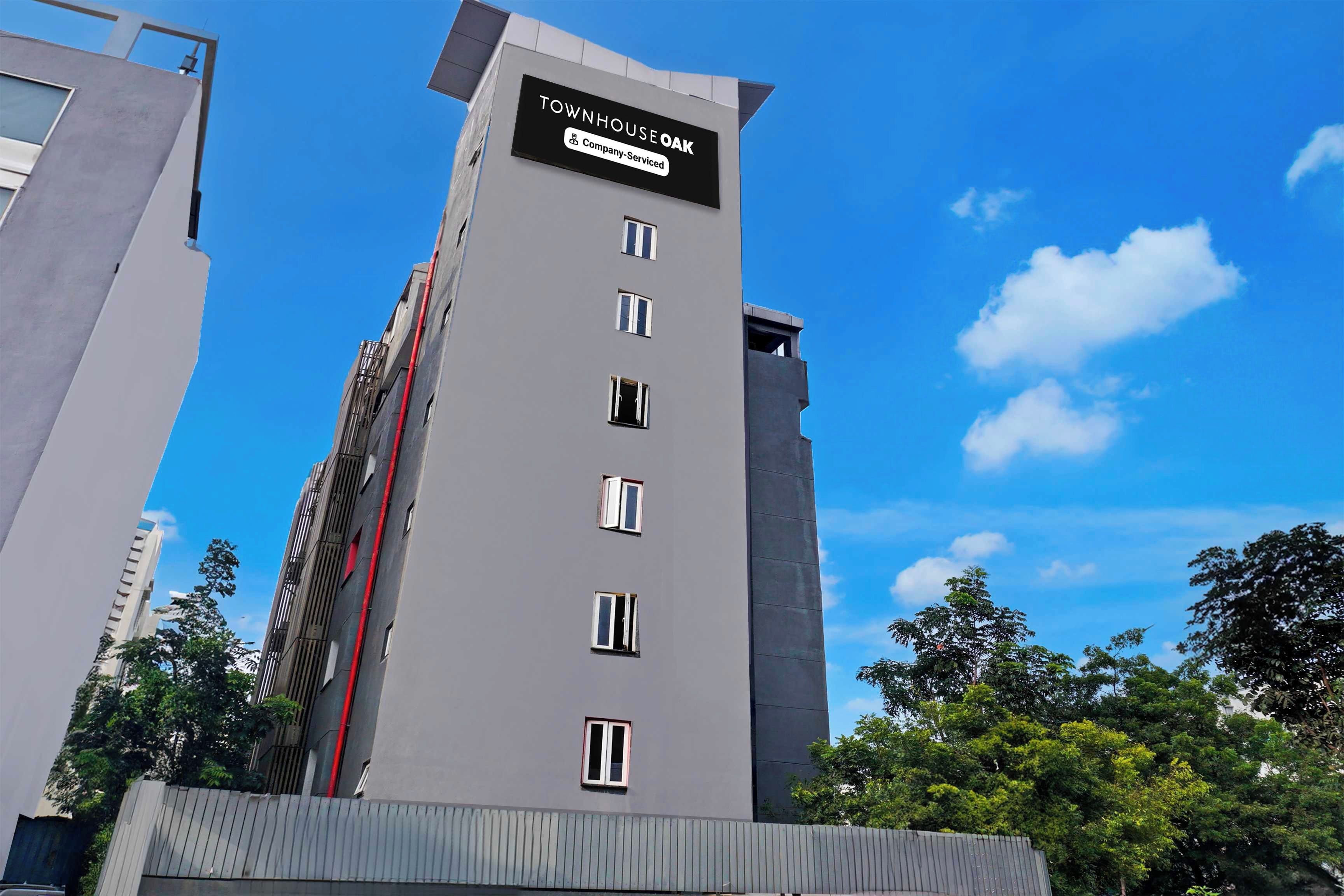A modern building with a sign indicating it is a company-serviced townhouse.