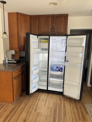 A kitchen with wooden cabinets, a refrigerator, and a coffee machine. -  Cozy1 bedroom Apt 1.5 bath in wonderful Ocean City near28st 2mints to boardwalk (Ocean City)
