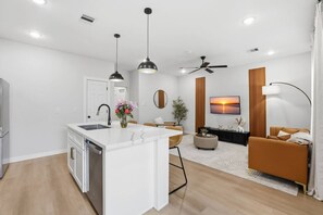 A modern apartment with a kitchen, dining area, and living room. - The NRG City Retreat (Houston)