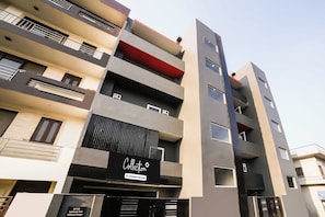 Un immeuble résidentiel à plusieurs étages, doté de balcons, d’une enseigne fournie par l’entreprise et d’une entrée sécurisée par un portail.