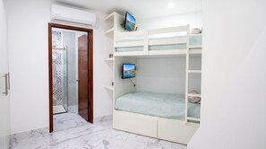 A bedroom with a bunk bed, a television mounted on the wall, and a door leading to a bathroom. - The Five Apartments by Monyxbnb (Puerto Vallarta)