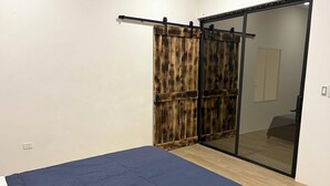 A bedroom with a bed, a sliding door, and a mirror. - Luxury Modern Ranch, Private Pool & Farm Animals (santa cruz)