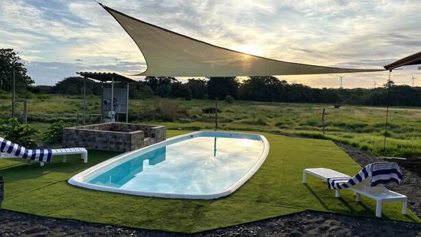 A swimming pool with a sunshade, lounge chairs, and a grassy area. - Luxury Modern Ranch, Private Pool & Farm Animals (santa cruz)