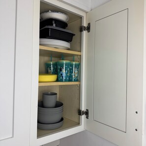 Ein Schrank mit Regalen, der verschiedene Küchenutensilien beherbergt.