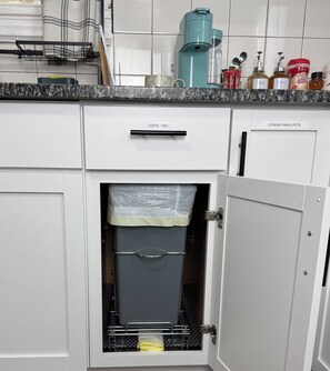 Eine Küche mit Kaffeemaschine, Wasserkocher und Kaffeemühle auf der Arbeitsfläche.