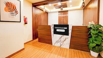 Un mostrador de recepción con un cartel que indica 'Townhouse Oak' y 'Company Serviced'.