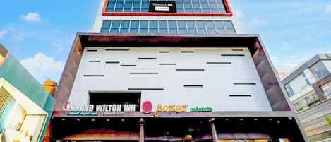 A multi-story building with a business hotel and a company service sign.