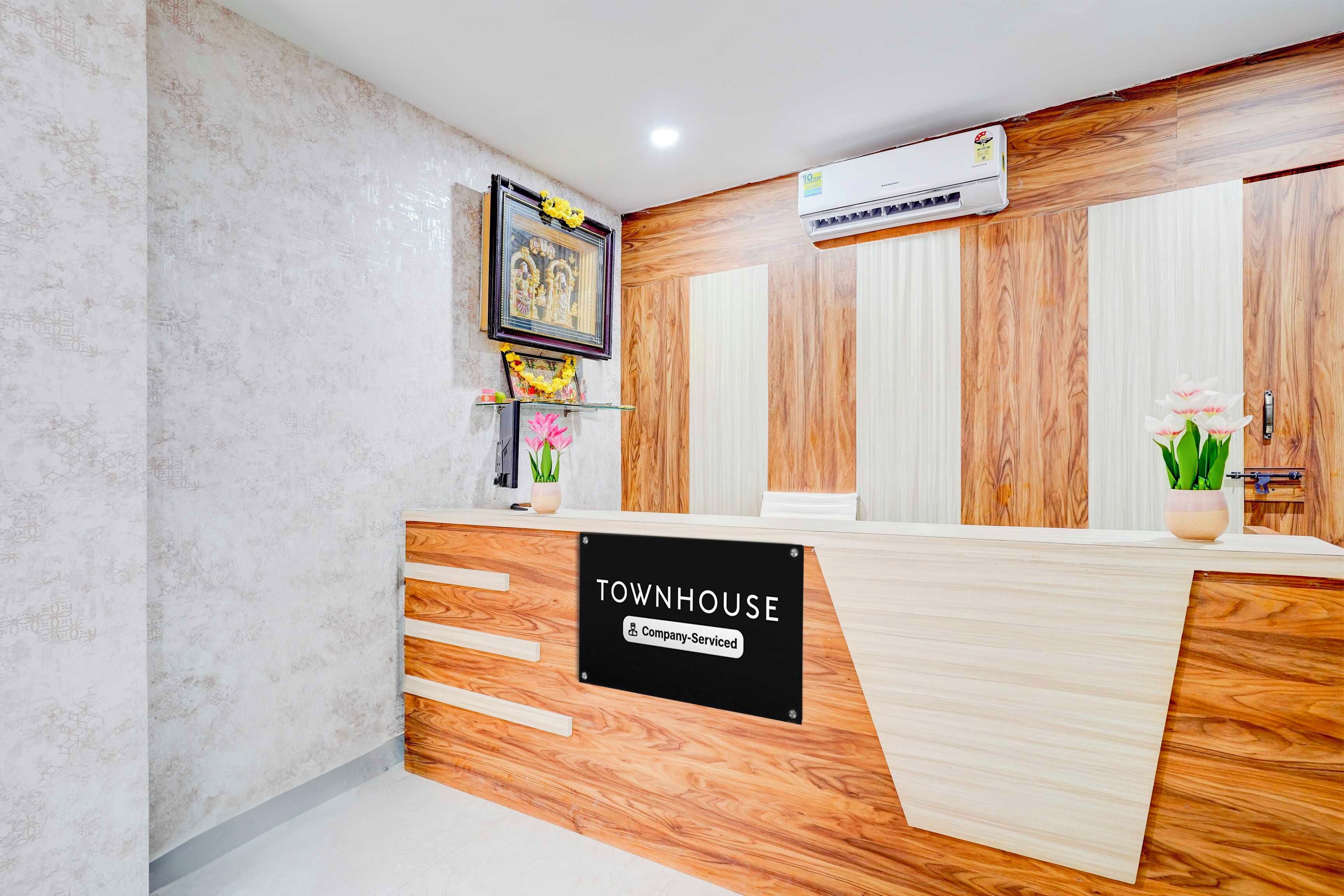 A reception desk with a 'TOWNHOUSE' sign, a framed picture, and a potted plant.