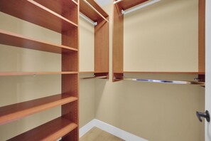 A walk-in closet with wooden shelves and a hanging rod. - Game loft retreat & patio near the Strip 5BR (Las Vegas)