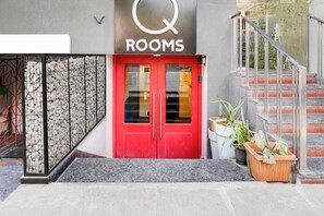 A red door with a glass panel and a sign above it.