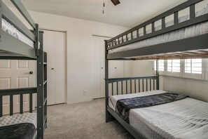 Habitación con literas, una puerta y una ventana.
