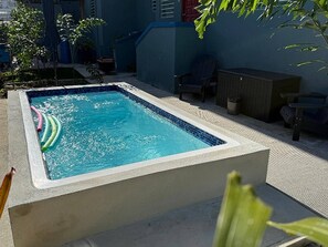 A rectangular swimming pool with a tiled edge, surrounded by a concrete deck and a low wall. - Lovely 2 Bedrooms Apartment With Terrace, Small Pool Share (San Juan)