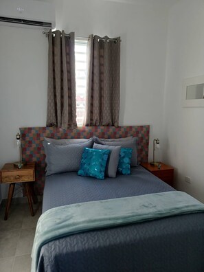 A bedroom with a bed, curtains, a patterned headboard, and bedside tables. - Lovely 2 Bedrooms Apartment With Terrace, Small Pool Share (San Juan)