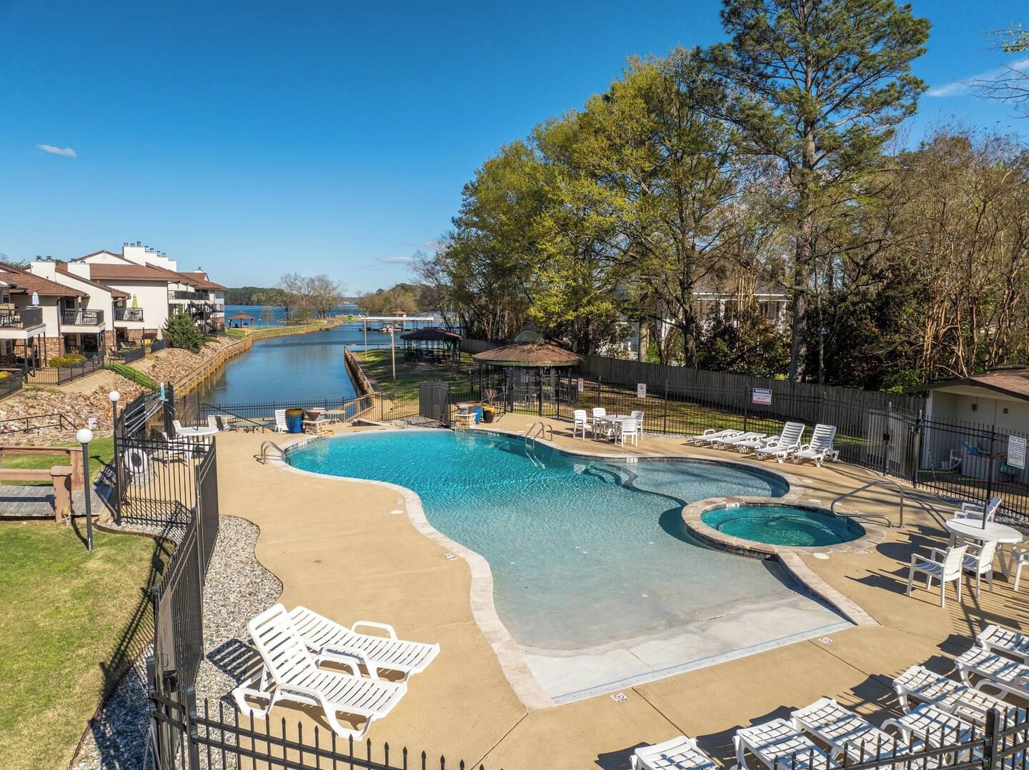 A swimming pool with lounge chairs and a view of a body of water.