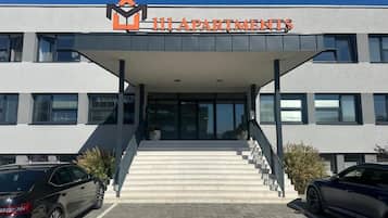 A building with a sign reading '111 APARTMENTS' and a staircase leading to the entrance.