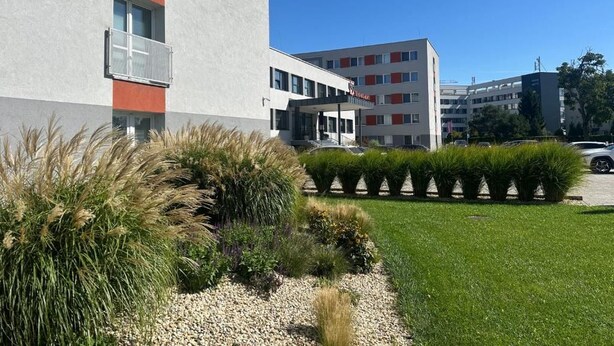A modern building with a flat facade, a balcony, and a clear sky. - 111Apartments (Košický kraj)