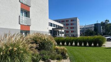 Un edificio moderno con fachada plana, un balcón y cielo despejado.