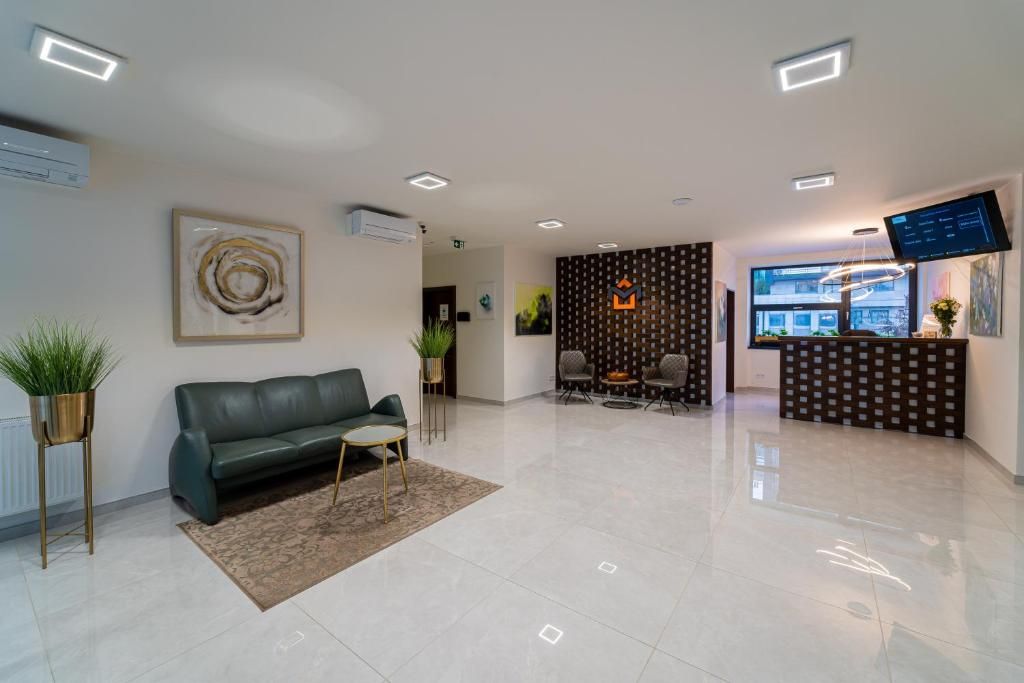 A modern reception area with a sofa, a coffee table, and a patterned wall.