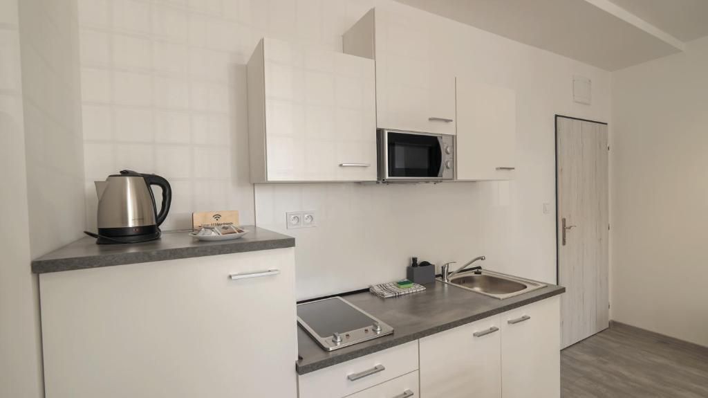 A compact kitchen with a microwave, kettle, and a small countertop area.