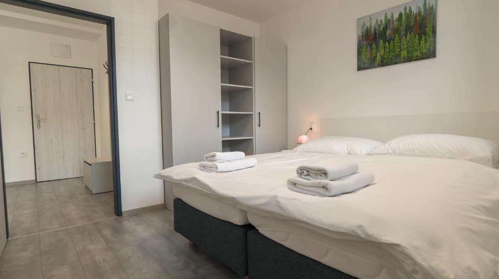Een slaapkamer met een bed, een garderobe en een schilderij aan de muur.