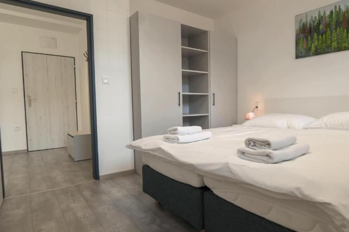 Ein Schlafzimmer mit einem Bett, einem Kleiderschrank und einem Gemälde an der Wand.