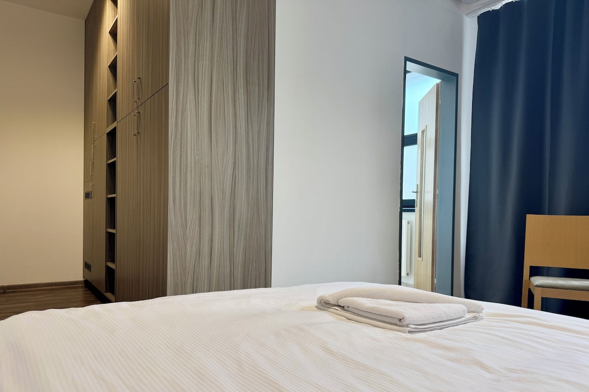 Ein Hotelzimmer mit einem großen Bett, einem Schrank und Blick ins Freie.