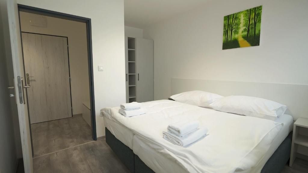 A bedroom with a bed, a wardrobe, and a painting on the wall.