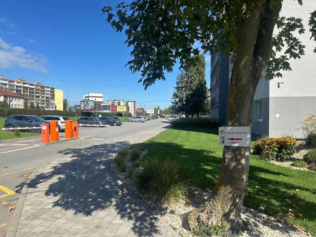 Vista de calle con entrada protegida por un portón, un letrero que dice 'ILAPPORTANTI for GUESTS' y un edificio con un letrero.