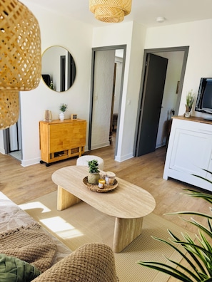 Un soggiorno moderno con un tavolino in legno, un armadietto bianco e una lampada in vimini.