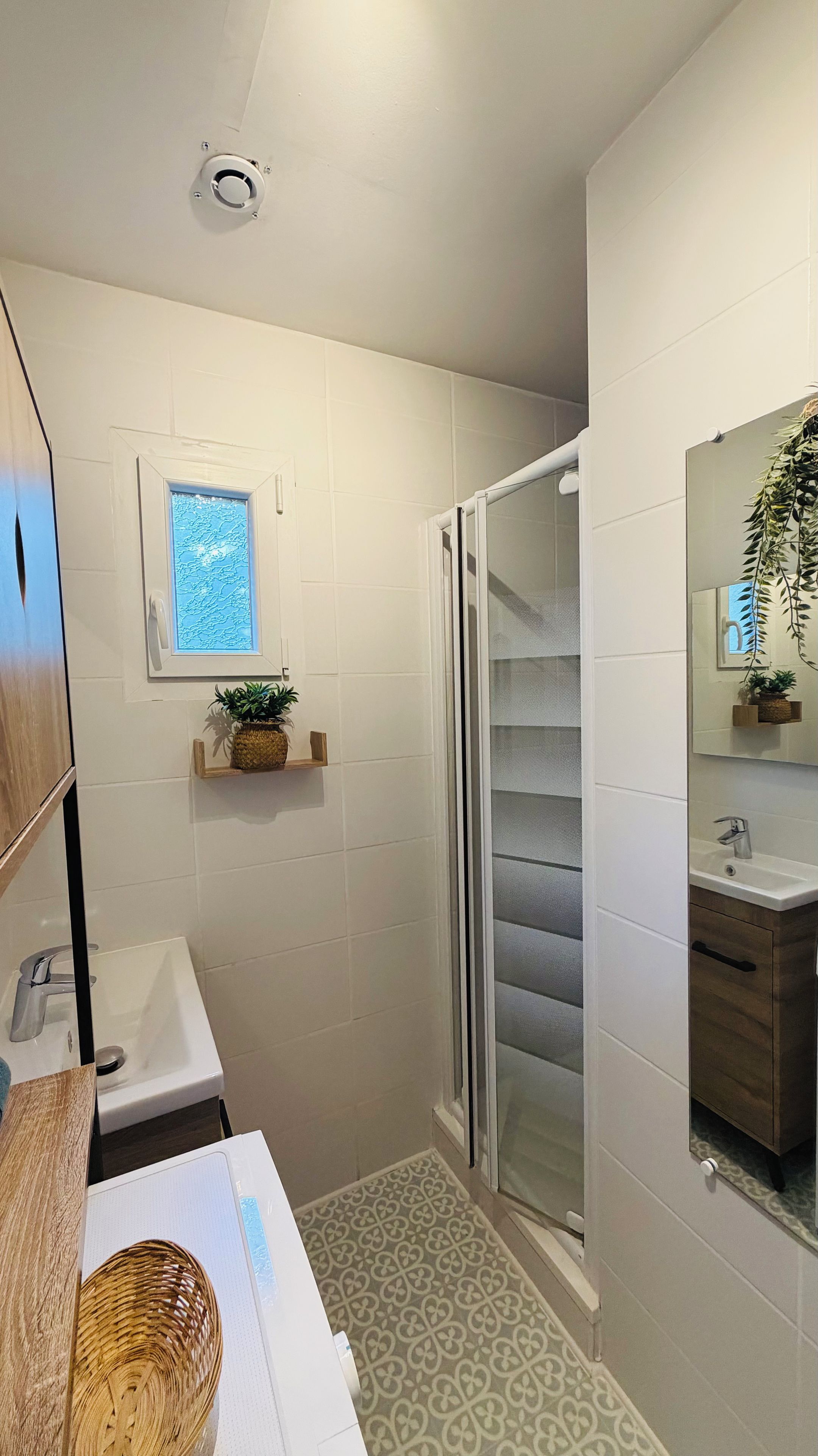 Une salle de bain moderne avec une douche, un lavabo et un miroir.