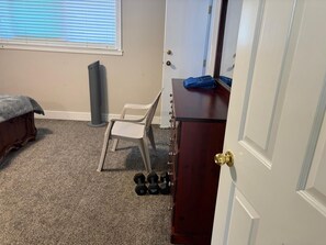 A room with a bed, a chair, a dresser, and a window with blinds. - Charming bungalow in wonderful Surrey perfect for a relaxing getaway (Surrey)