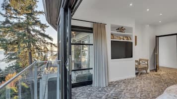 Una habitación con un ventanal, una silla y una cama.
