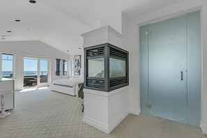 Ein Hotelzimmer mit großem Fenster, einem Bett, einem Schreibtisch und einem Kleiderschrank.