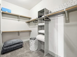 A walk-in closet with shelves, a hanging rod, and a storage bin. - Cozy 1-bedroom apartment in the historic Bishop Arts area. (Dallas)