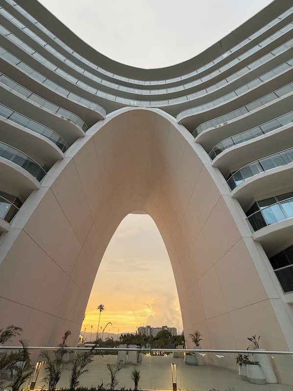 Um edifício moderno com fachada curva e várias varandas.