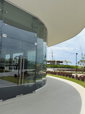 Un bâtiment moderne doté d’une façade en verre incurvée et d’une galerie couverte.