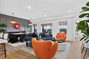 A modern living room with a dining area, large windows, and a view of the outdoors. - Lakefront Retreat at Table Rock Lake (Kimberling City)