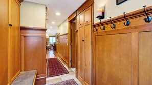 Un couloir avec des portes en bois et une moquette rouge.