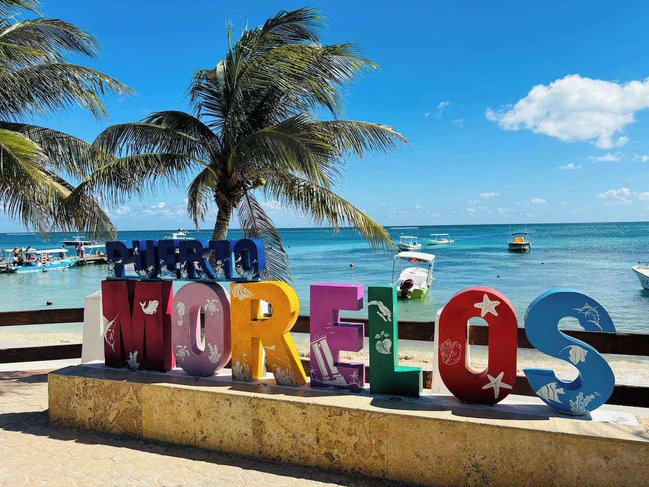 A beachside sign with the word 'Morelos' and palm trees in the background.