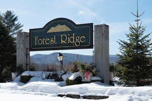 A sign for 'Forest Ridge' with a mountainous backdrop. - New 2026 Build · 3 Min to Loon · Movie Room · Pool & Hot Tub · Sleeps 20 (Lincoln)
