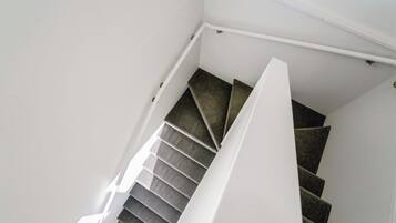 A staircase with carpeted steps and white handrails.