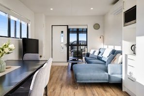Una sala de estar moderna con un sofá, una mesa de comedor y una zona de cocina.