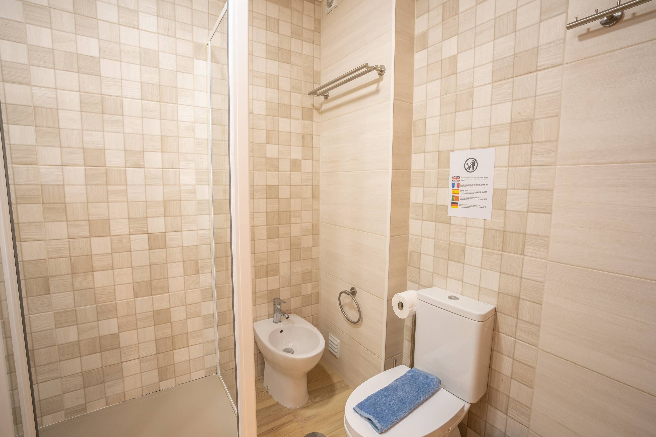 A bathroom with a bidet, toilet, and a towel.