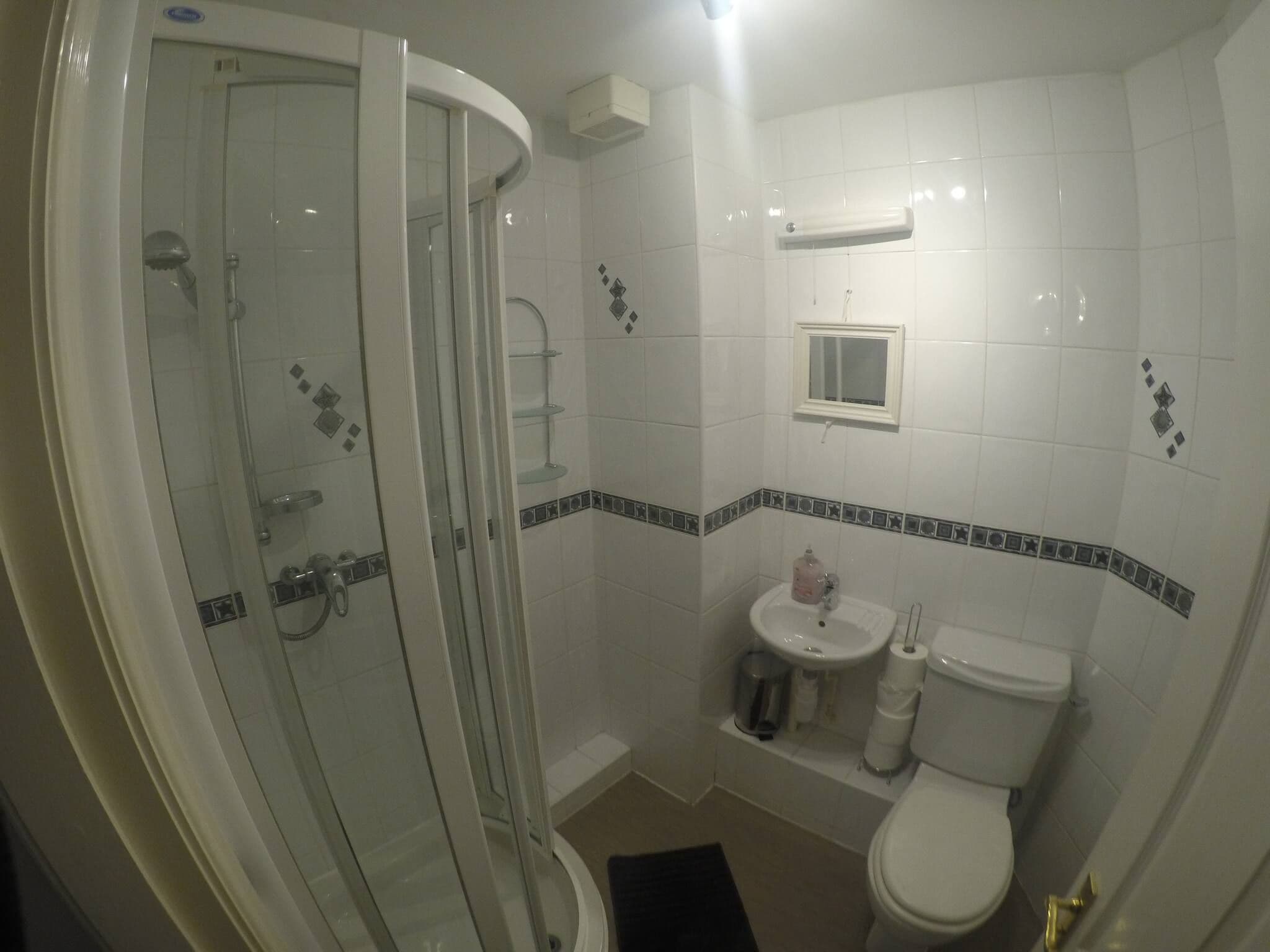 Une salle de bain avec une douche à parois de verre, un lavabo et des toilettes.